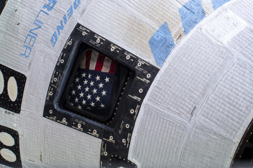 In this photo provided by NASA, a U.S. flag is displayed from a window of the Boeing Starliner spacecraft docked to the International Space Station on Tuesday, July 2, 2024. (NASA via AP)