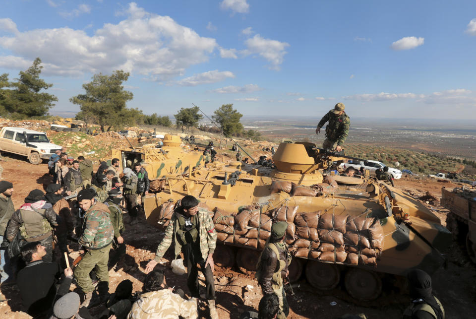 FILE - This Jan. 28, 2018 file photo, Turkish troops and pro-Turkey Syrian fighters try to take control of Bursayah hill, which separates the Kurdish-held enclave of Afrin from the Turkey-controlled town of Azaz, Syria. The planned U.S. troop withdrawal opens a void in the north and east of Syria, and the conflicts and rivalries among all the powers in the Middle East are converging to fill it. (AP Photo, File)