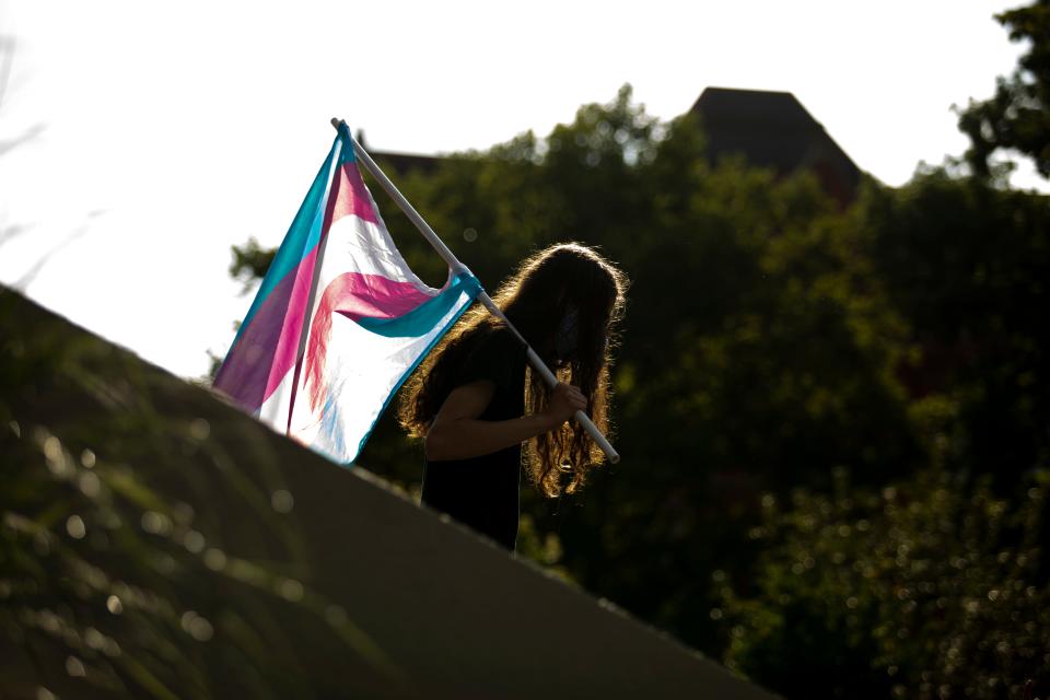 A person carries a transgender flag at Washington Park in downtown Cincinnati during the "Trans Black Lives Matter" event hosted by the Party for Socialism and Liberation on Tuesday, June 30, 2020. 