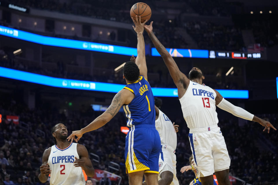 Golden State Warriors guard Cory Joseph (1) and Los Angeles Clippers forward Paul George (13) jump for the ball during the first half of an NBA basketball game Thursday, Nov. 30, 2023, in San Francisco. (AP Photo/Godofredo A. Vásquez)