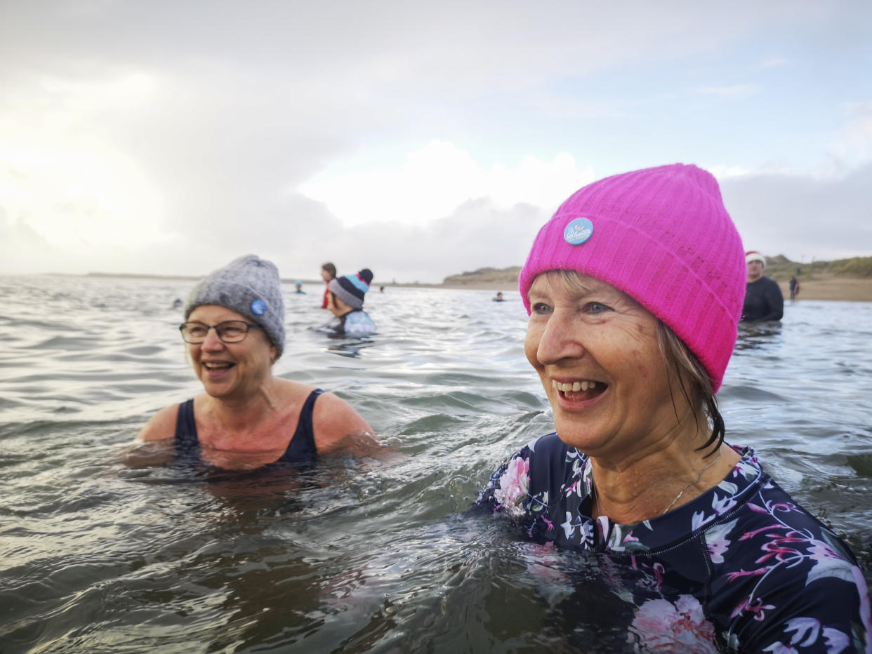 Burry Port, Wales, UK: December 26, 2021: A group of mature female friends swimming in the sea. The Bluetits Chill Swimmers Ltd is a social enterprise committed to empowering our inclusive community of outdoor dippers.