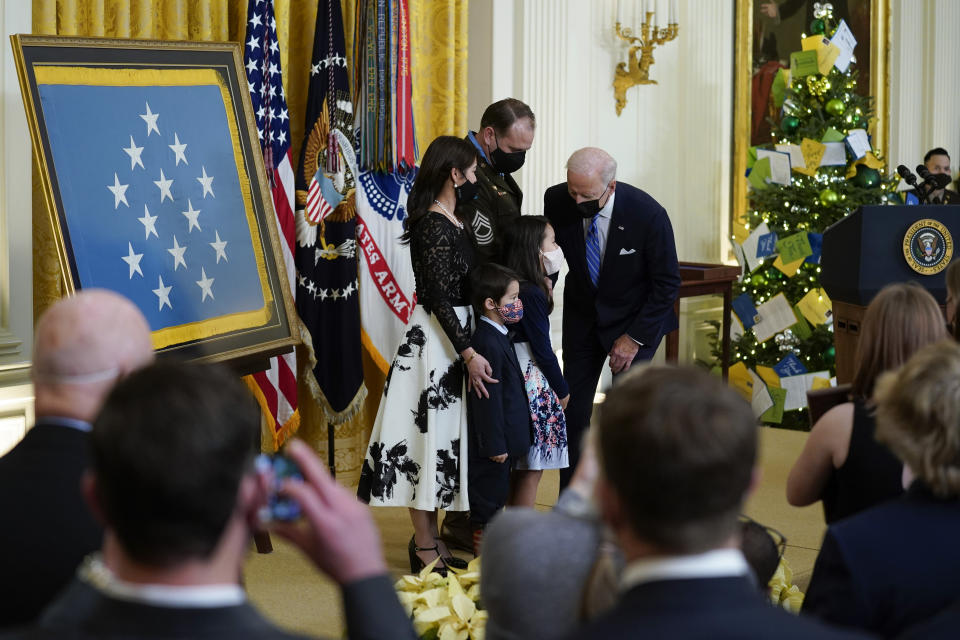 President Joe Biden stands with Army Master Sgt. Earl Plumlee and his family after presenting Plumlee with the Medal of Honor for his actions in Afghanistan on Aug. 28, 2013, during an event in the East Room of the White House, Thursday, Dec. 16, 2021, in Washington. (AP Photo/Evan Vucci)