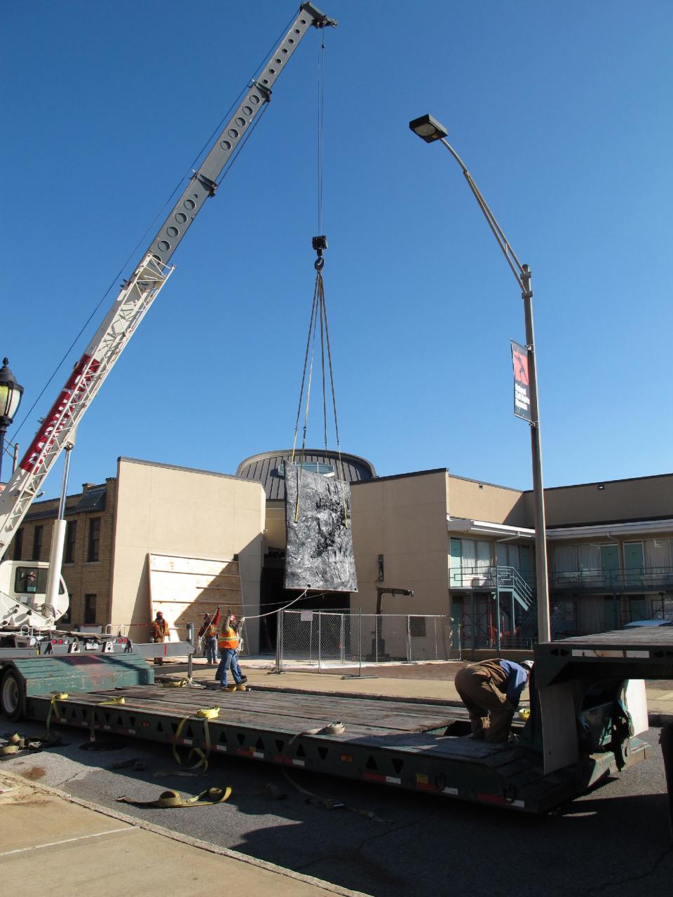 A crane moves a piece of a 7-ton sculpture from the lobby of the National Civil Rights Museum onto a flatbed truck on Tuesday, Dec. 11, 2012 in Memphis Tenn. The sculpture was moved from the museum to make room for crews doing renovation work, which is expected to be completed in early 2014. The museum is located at the site of the old Lorraine Motel, which is where Martin Luther King Jr. was assassinated in 1968 in Memphis. (AP Photo/Adrian Sainz)