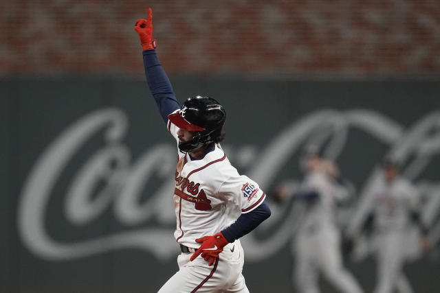 Atlanta Braves' Adam Duvall, right, celebrates his two-run home run in the  dugout during the third inning of Game 1 in baseball's World Series between  the Houston Astros and the Atlanta Braves