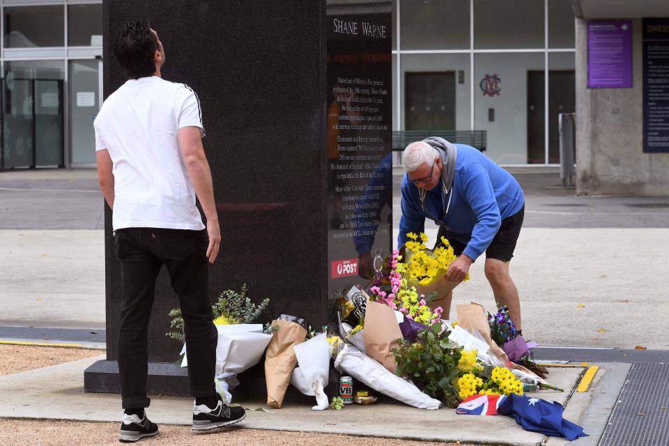 Pictured here, fans place flowers at a statue of former Aussie cricket great Shane Warne outside the Melbourne Cricket Ground.