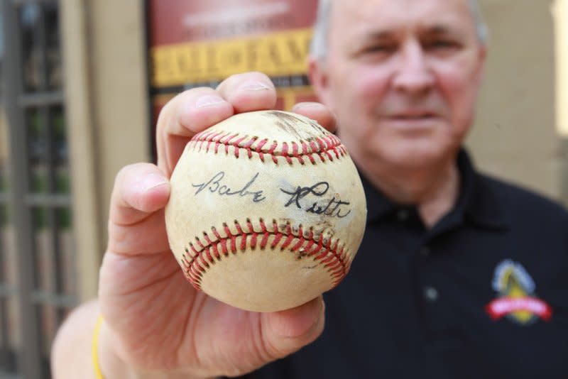 Patrick Hannon Sr. holds a baseball signed by Baseball Hall of Fame member Babe Ruth on opening day of the St. Louis Sports Hall of Fame Bar and Grill in Maryland Heights, Mo., on March 30, 2012. On Aug. 16, 1948, Ruth died in New York of cancer at age 53. File Photo by Bill Greenblatt/UPI