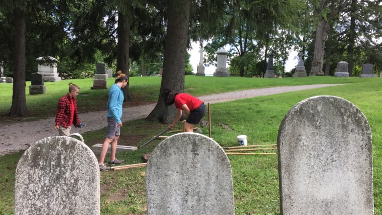 Western University students refurbishing tombstones