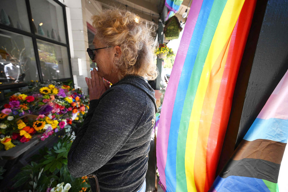 A resident reacts after leaving flowers at a makeshift memorial outside the Mag.Pi clothing store in Cedar Glen, near Lake Arrowhead, California, on August 21, 2023. The owner of the store, Laura Ann Carleton, was fatally shot on August 18 by a man who 