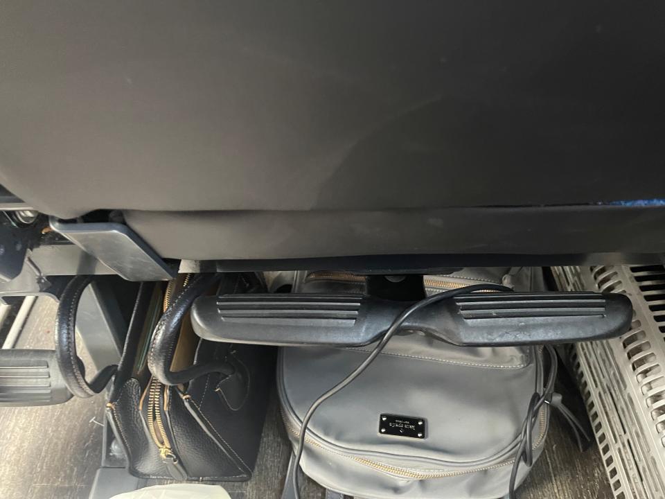 A view from the author's seat, where she has placed her backpack and a small purse under the seat in front of her.