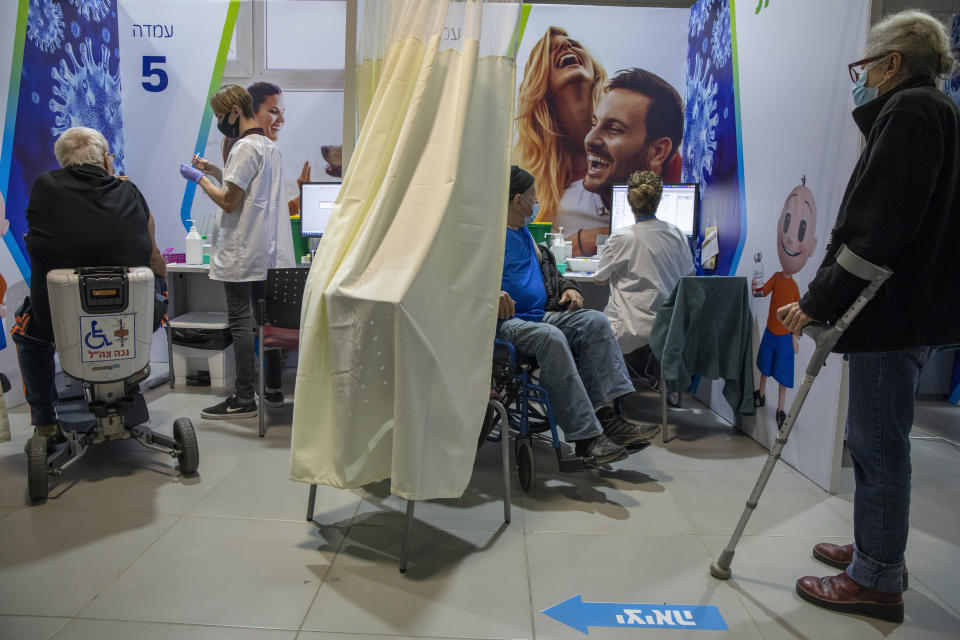 Israelis receive the second Pfizer-BioNTech COVID-19 vaccine, in Netanya, Israel, Tuesday, Jan. 12, 2021. Israel has struck a deal with Pfizer, promising to share vast troves of medical data with the drugmaker in exchange for the continued flow of its COVID-19 vaccine. Critics say the deal is raising major ethical concerns, including possible privacy violations and a deepening of the global divide between wealthy countries and poorer populations, including Palestinians in the occupied West Bank and Gaza, who face long waits to be inoculated. (AP Photo/Ariel Schalit)