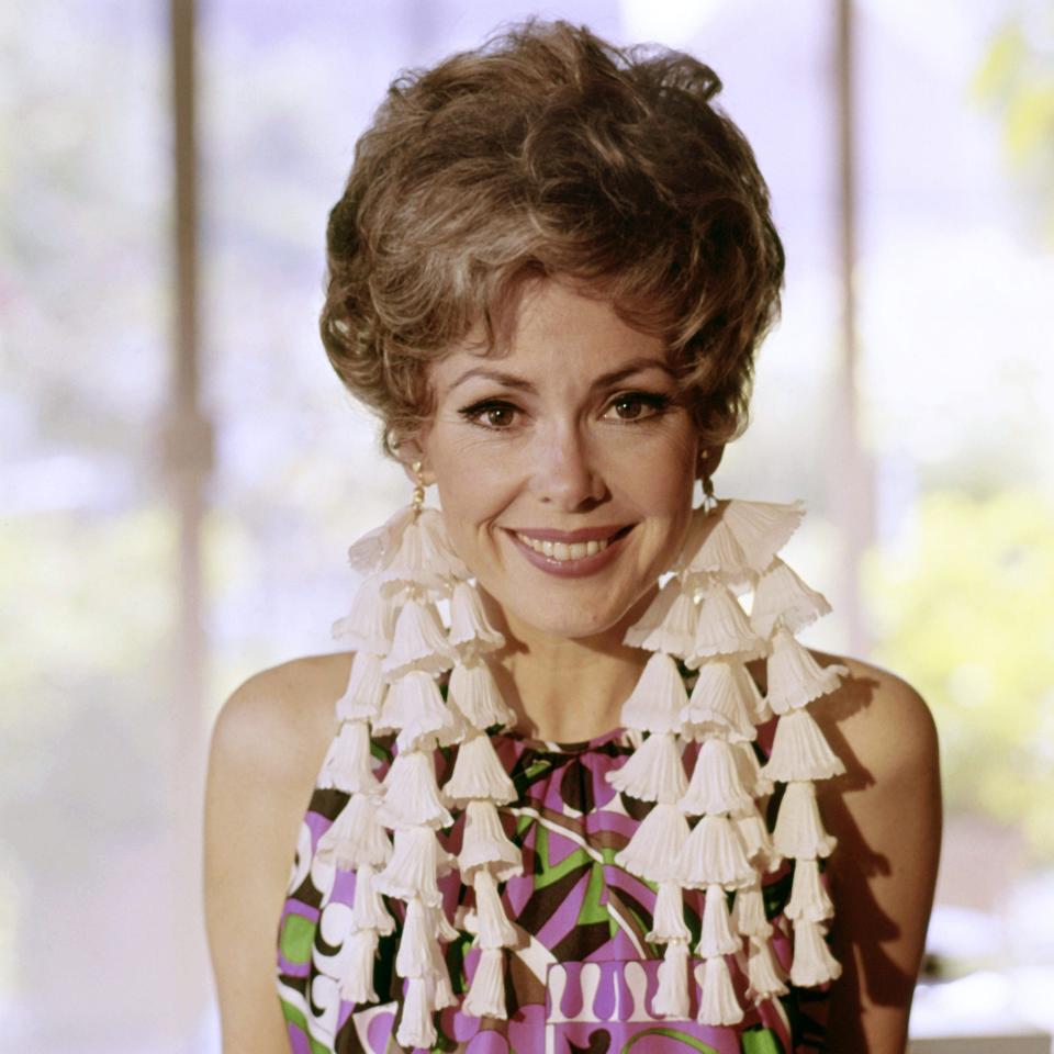 Barbara Rush smiling wearing colorful dress .