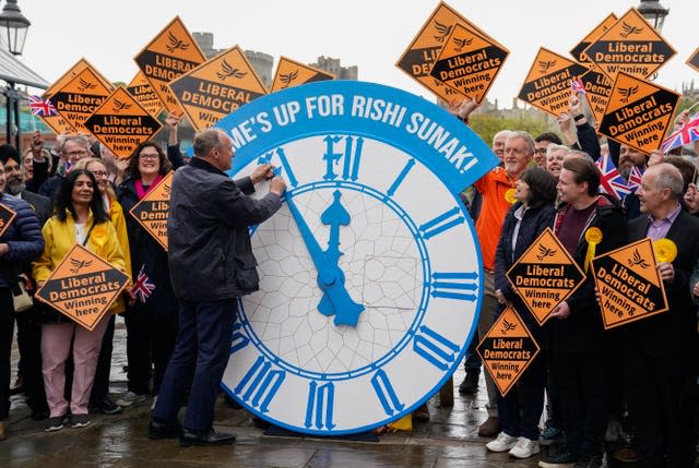 Ed Davey and a huge clock face that reads 'time's up for Rishi Sunak'
