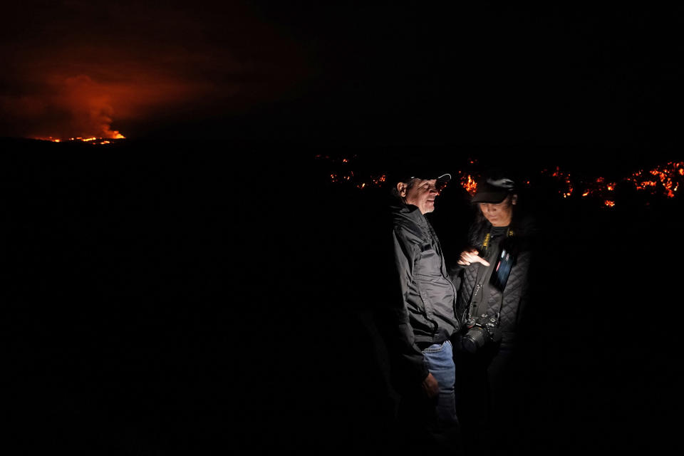 Journalists record images of lava from the Mauna Loa volcano as it erupts Wednesday, Nov. 30, 2022, near Hilo, Hawaii. (AP Photo/Gregory Bull)