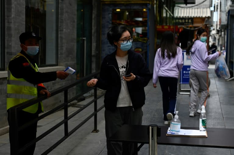 Contrôle de la température dans une rue de Pékin, le 9 mai 2022 (AFP/WANG Zhao)