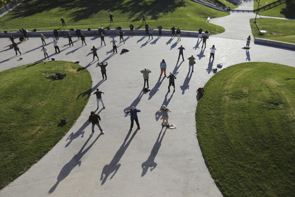 In this Oct. 7, 2019, photo, people perform tai chi at the Salt Lake City Public Library, in Salt Lake City. The participants are homeless people who take part in a free tai chi program run by a retired couple who started the classes three years ago by knocking on tents and peering around grocery carts near the Library to encourage people to join them. Bernie and Marita Hart had one participant in their first class. Now, more than 50 people regularly attend. (AP Photo/Rick Bowmer)