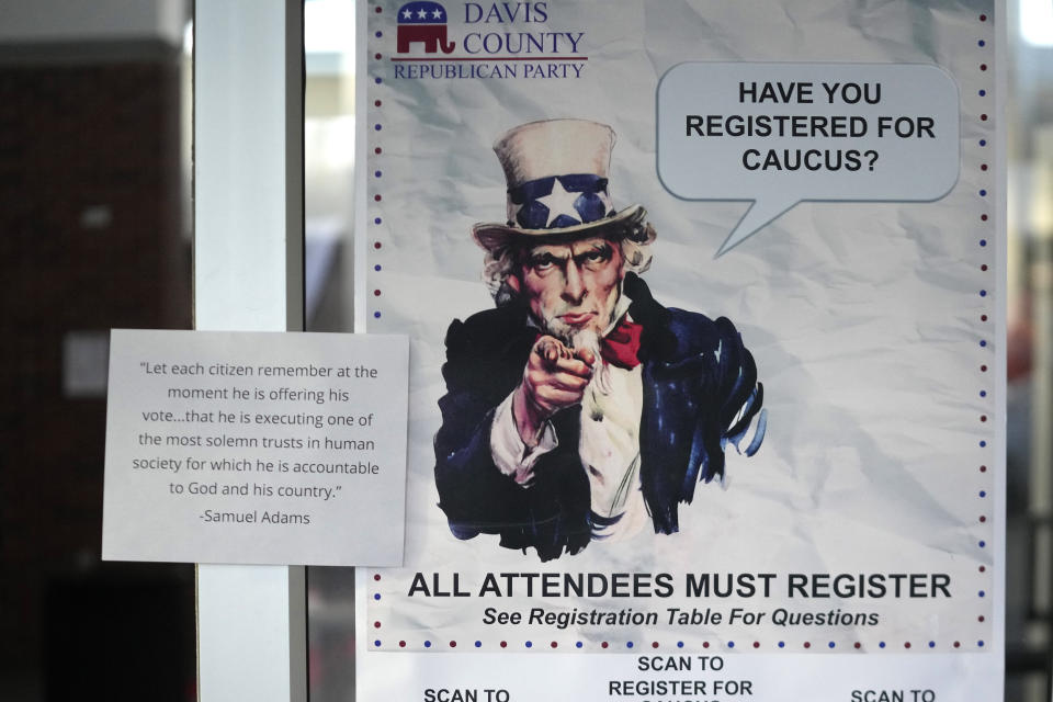 A HAVE YOU REGISTERED FOR CAUCUS sign hangs on a doorway during the Republican caucus at the Millcreek Junior High School on Tuesday, March 5, 2024, in Bountiful, Utah. Republican voters gathered at neighborhood precincts across Utah on Super Tuesday to select a presidential nominee through an in-person candidate preference poll. (AP Photo/Rick Bowmer)