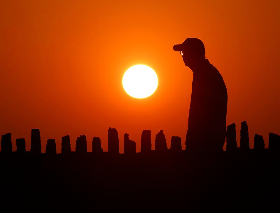 Exceptionally warm weather moved into the upper Midwest on Aug. 22 as a pedestrian walks at sunset in Oconomowoc, Wis. Climate scientist James Hansen  predicts that the Earth's temperature rise will accelerate in the upcoming decades.