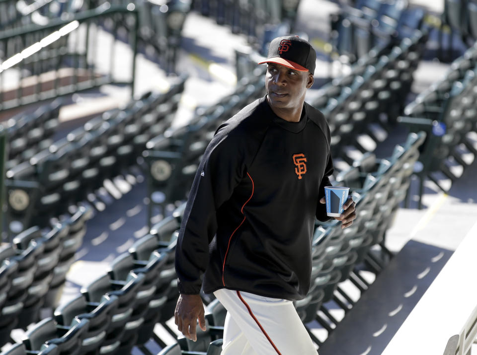 San Francisco Giants manager Bruce Bochy, left, listens as former player Barry Bonds arrives for a news conference before a spring training baseball game in Scottsdale, Ariz., Monday, March 10, 2014. Bonds starts a seven day coaching stint today. (AP Photo/Chris Carlson)