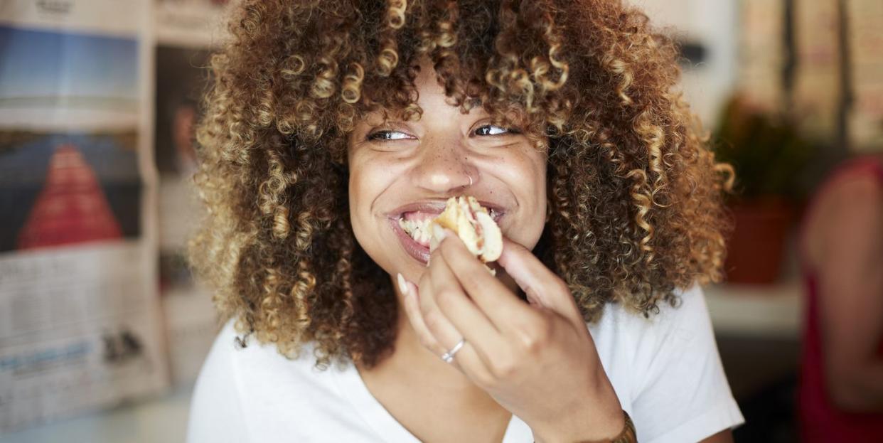 black woman biting sandwich