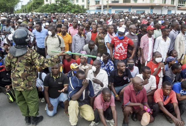 Kenyan police hold back ferry passengers in Mombasa