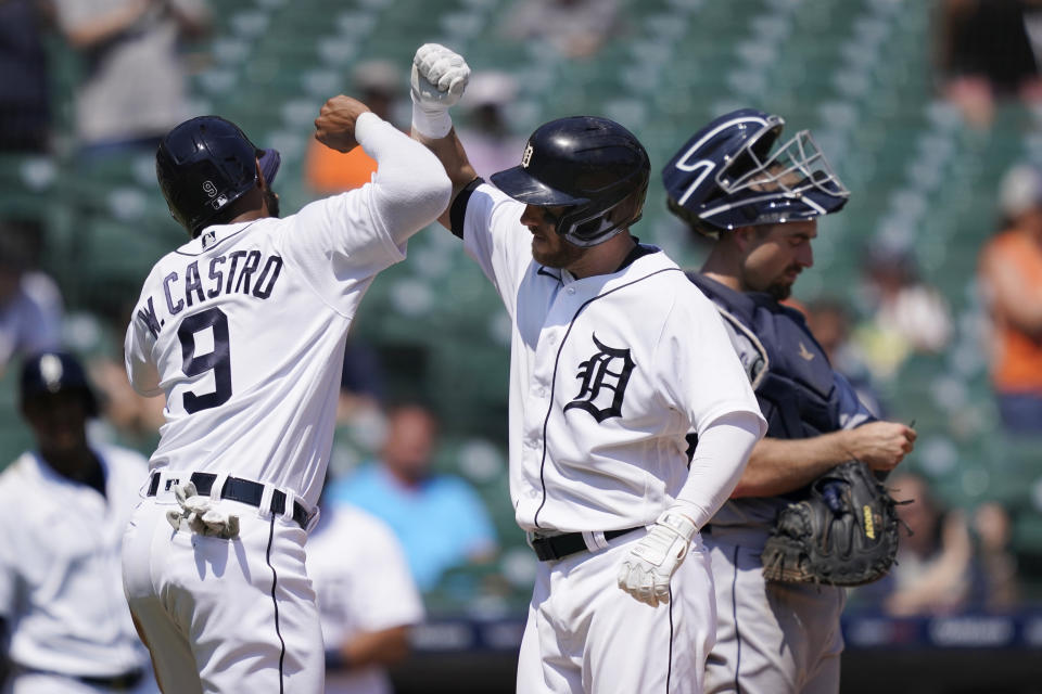 Detroit Tigers' Willi Castro greets Robbie Grossman next to Seattle Mariners catcher Tom Murphy after they scored on Grossman's two-run home run during the sixth inning of a baseball game, Thursday, June 10, 2021, in Detroit. (AP Photo/Carlos Osorio)