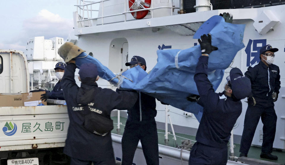 The members of Japanese Coast Guard carry the debris which are believed to be from the crashed U.S. military Osprey aircraft, at a port in Yakushima, Kagoshima prefecture, southern Japan, Monday, Dec. 4, 2023. Japanese and American military divers have spotted what could be the remains of a U.S. Air Force Osprey aircraft that crashed last week off southwestern Japan and several of the six crewmembers who are still missing, local media reported Monday.(Kyodo News via AP)