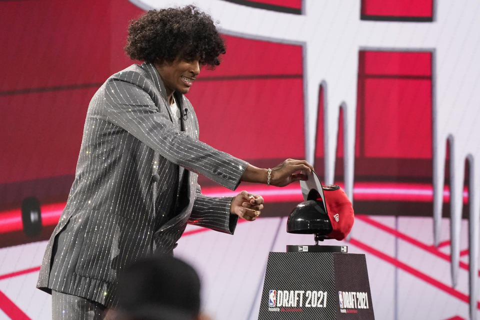 Jalen Green picks up a Houston Rockets cap after he was selected by the Houston Rockets as the second overall pick during the first round of the NBA basketball draft, Thursday, July 29, 2021, in New York. (AP Photo/Corey Sipkin)