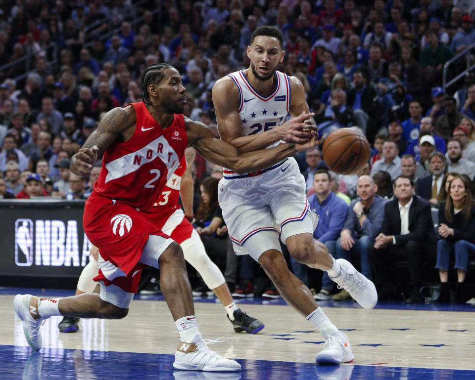 Toronto Raptors' Kawhi Leonard, left, tries to knock the ball away from Philadelphia 76ers' Ben Simmons during the first half of Game 6 of a second-round NBA basketball playoff series Thursday, May 9, 2019, in Philadelphia. (AP Photo/Chris Szagola)