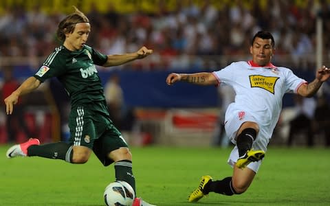 Real Madrid's Luka Modric prepares to shoot the ball in front of Sevilla's Gary Medel  - Credit: AFP