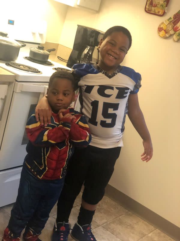 Shanell McGee's sons, 8 year-old DaMir Coleman and 4 year-old KyMir Coleman, stand beside their oven that they use for heat, in Columbus, Ohio