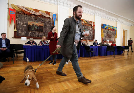 A voter with a dog visits a polling station during the second round of a presidential election in Kiev, Ukraine April 21, 2019. REUTERS/Vasily Fedosenko