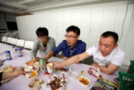 Han Liqun (C), a HR manager of RenRen Credit Management Co., drinks with his colleagues Kou Meng (L) and Ma Zhenguo after finishing work, after midnight, in Beijing, China, April 27, 2016. REUTERS/Jason Lee