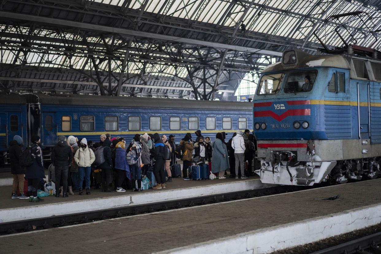 People trying to flee Ukraine stand on a platform as they wait for trains inside Lviv railway station on Monday, Feb. 28, 2022, in Lviv, west Ukraine. Russia's military assault on Ukraine has entered its fifth day, forcing hundreds of thousands of Ukrainians and foreign residents to escape from war and seek refuge in neighboring countries.