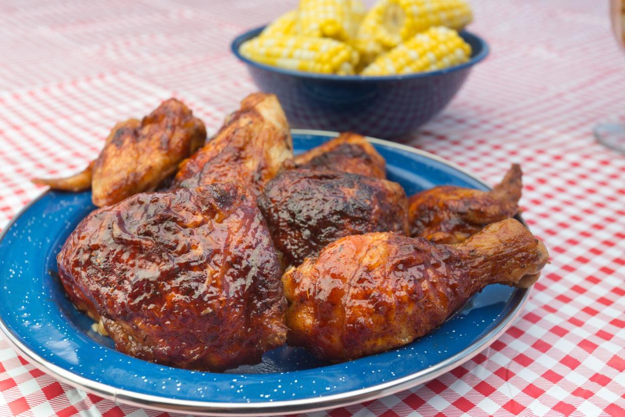 Barbecue Chicken and iced tea with corn on the cob, baked beans and potato salad on gingham