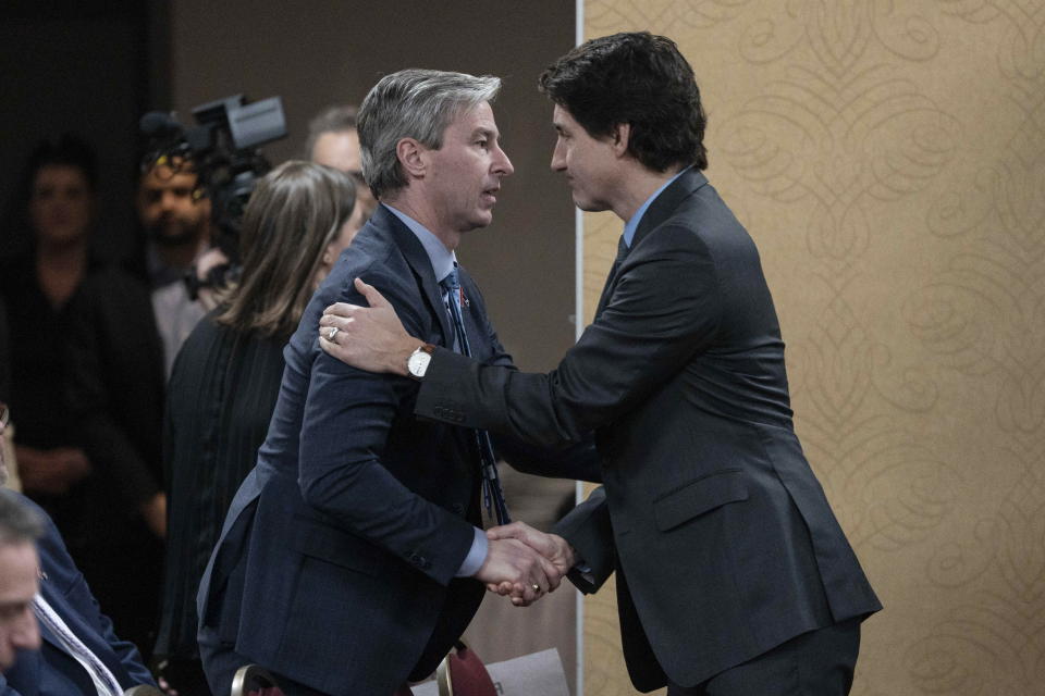 Prime Minister Justin Trudeau, right, is greeted by Nova Scotia Premier Tim Houston prior to the release of a final report of the Mass Casualty Commission inquiry into the mass murders in rural Nova Scotia in Truro, Nova Scotia, Thursday, March 30, 2023. (Darren Calabrese/The Canadian Press via AP)