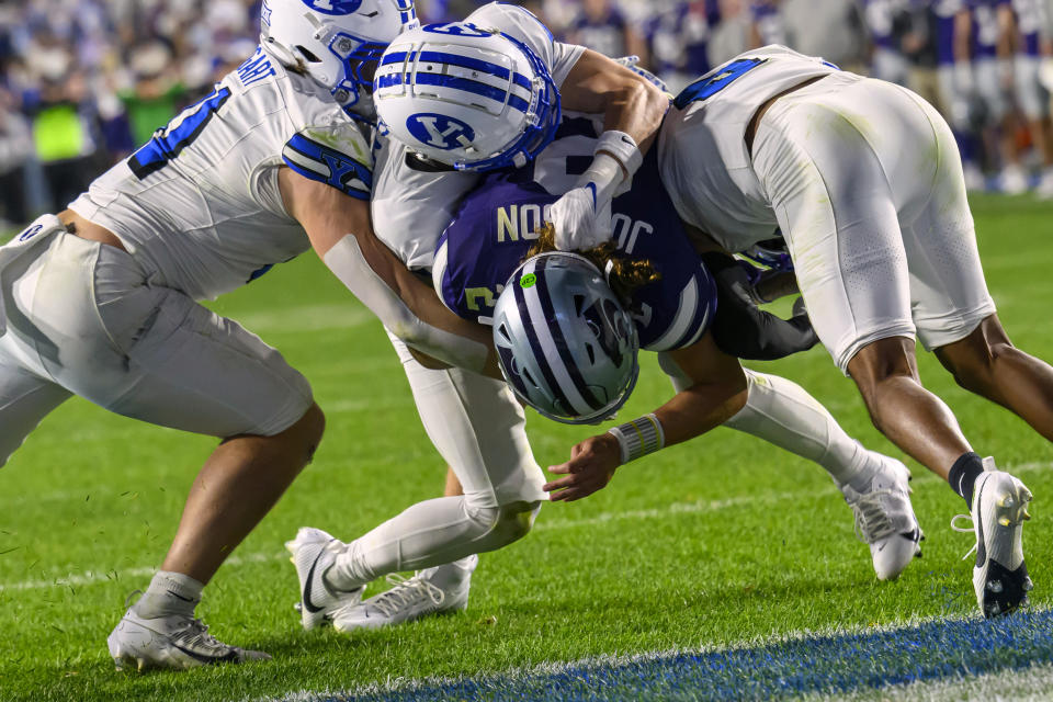 Brigham Young safety Tommy Prassas, center top, cornerback Jakob Robinson, right, and linebacker Harrison Taggart, left, stop Kansas State quarterback Avery Johnson, center bottom, short of the goal line during an NCAA football game on Saturday, Sept. 21, 2024 in Provo, Utah. (AP Photo/Tyler Tate)