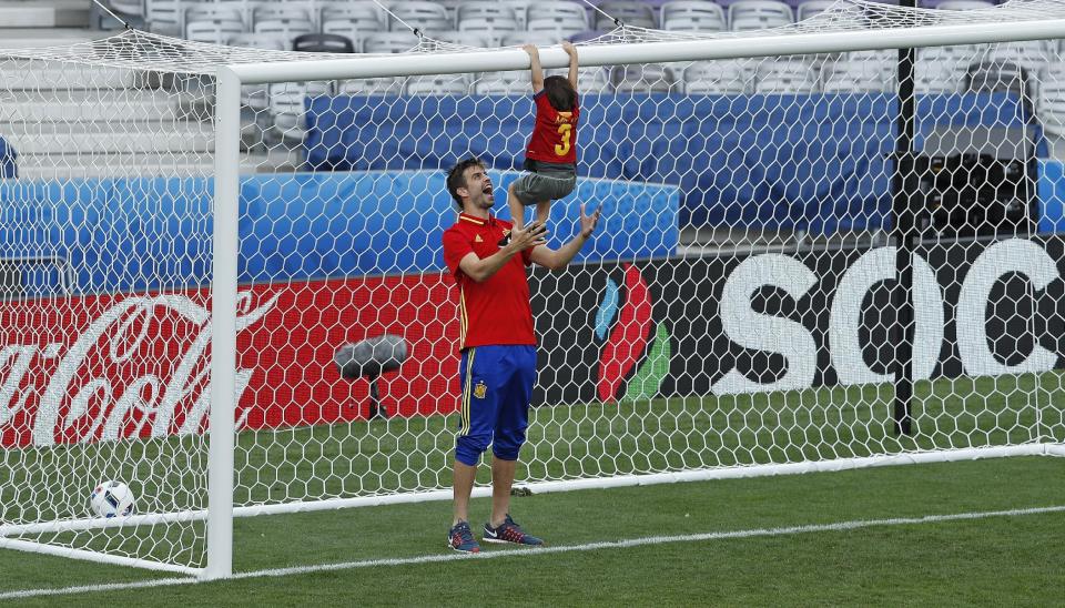 Gerard Piqué jugando con su hijo Milan en el estadio del Toulouse (AP Photo/Hassan Ammar)