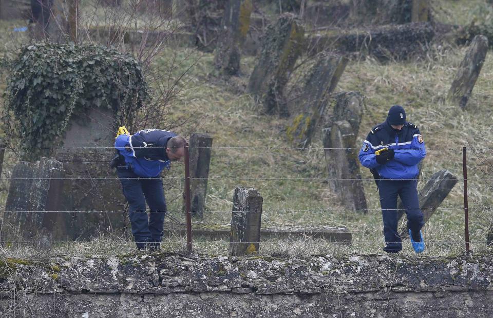 French gendarmes investigate near desecrated tombstones at the Sarre-Union Jewish cemetery, eastern France