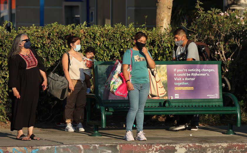 VAN NUYS, CA -SEPTEMBER 1, 2022: People wait for the Metro bus to arrive at a bus stop with no shade on Sepulveda Blvd. in Van Nuys.The city is about to contract for new shade and there's a big push among activists to do better. (Mel Melcon / Los Angeles Times)