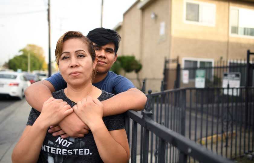 CUDAHY, CALIFORNIA NOVEMBER 20, 2020-Adrian Rivera hugs his mother Yesica Aguirre outside there apartment complex in Cudahy. Aguirre is torn about sending her son, who is doing well online, back to campus because of health risks. (Wally Skalij/Los Angeles Times)