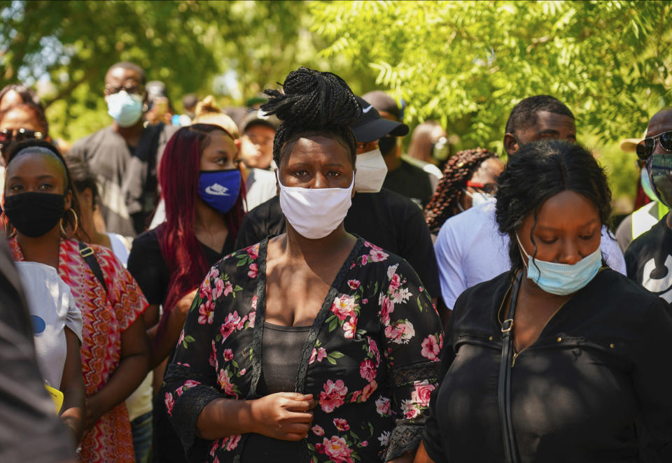 Angel Fuller, center, and Diamond Alexandria, right, Robert Fuller's sisters, attended a rally under a tree, left, Saturday, June 13, 2020, where the body of Robert Fuller was found hanging from a tree, Wednesday, June 10 in Poncitlan Square in Palmdale, Calif. The protesters marched from where the body was found to a sheriff's station, with many carrying signs that said "Justice for Robert Fuller." (Francisco Lozano via AP)