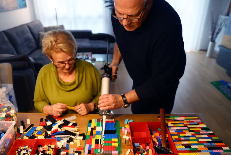 Rita Ebel (L), nicknamed "Lego grandma", and her husband Wolfgang build a wheelchair ramp from donated Lego bricks in the living room of their flat in Hanau