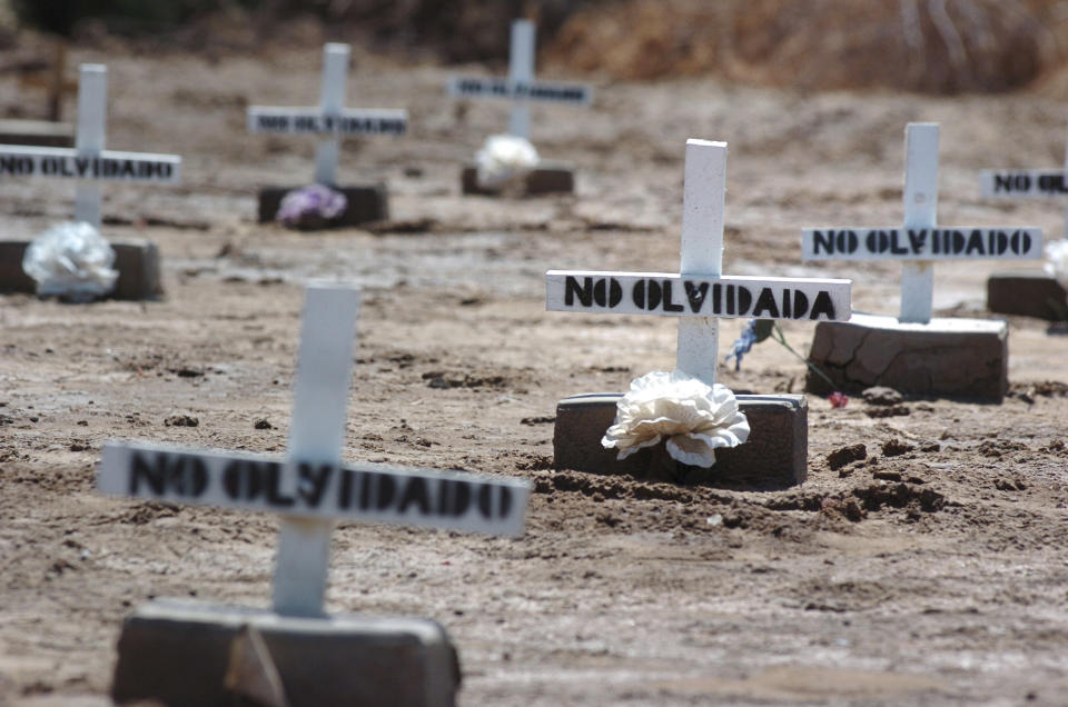 FILE - In this Thursday, May 18, 2006 file photo, white crosses and cement bricks mark the graves where unidentified migrants who died while crossing the border are buried in a public cemetery in Holtville, Calif. Several hundred such graves are located in the cemetery. The crosses read "not forgotten". (AP Photo/David Maung)