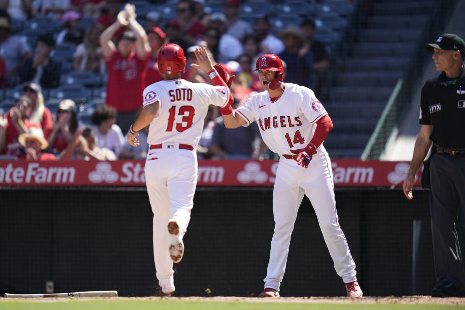 Los Angeles Angels' Livan Soto (13) and Logan O'Hoppe (14) celebrate as they score off of a single hit by David Fletcher during the first inning of a baseball game against the Texas Rangers in Anaheim, Calif., Sunday, Oct. 2, 2022. (AP Photo/Ashley Landis)