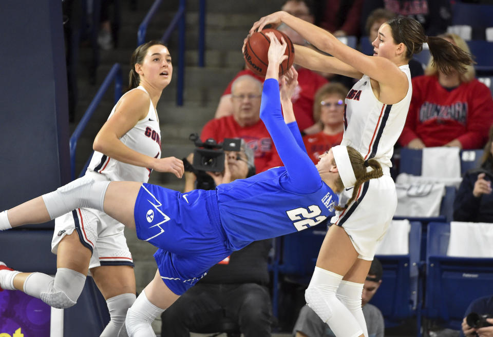 In this Saturday, Feb. 1, 2020 photo, Gonzaga forward Jenn Wirth (3) blocks BYU center Sara Hamson (22) as her twin sister LeeAnn Wirth looks on at left during the first half of an NCAA college basketball game in Spokane, Wash. (Tyler Tjomsland/The Spokesman-Review via AP)