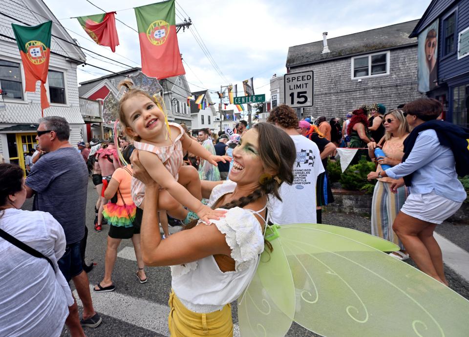 Leal Constanza of Wellfleet lifts her fellow fairy Niah Woods, 2, to the music played before the Carnival parade passed with the theme of "Monsters, Myths & Legends" on Aug. 18.