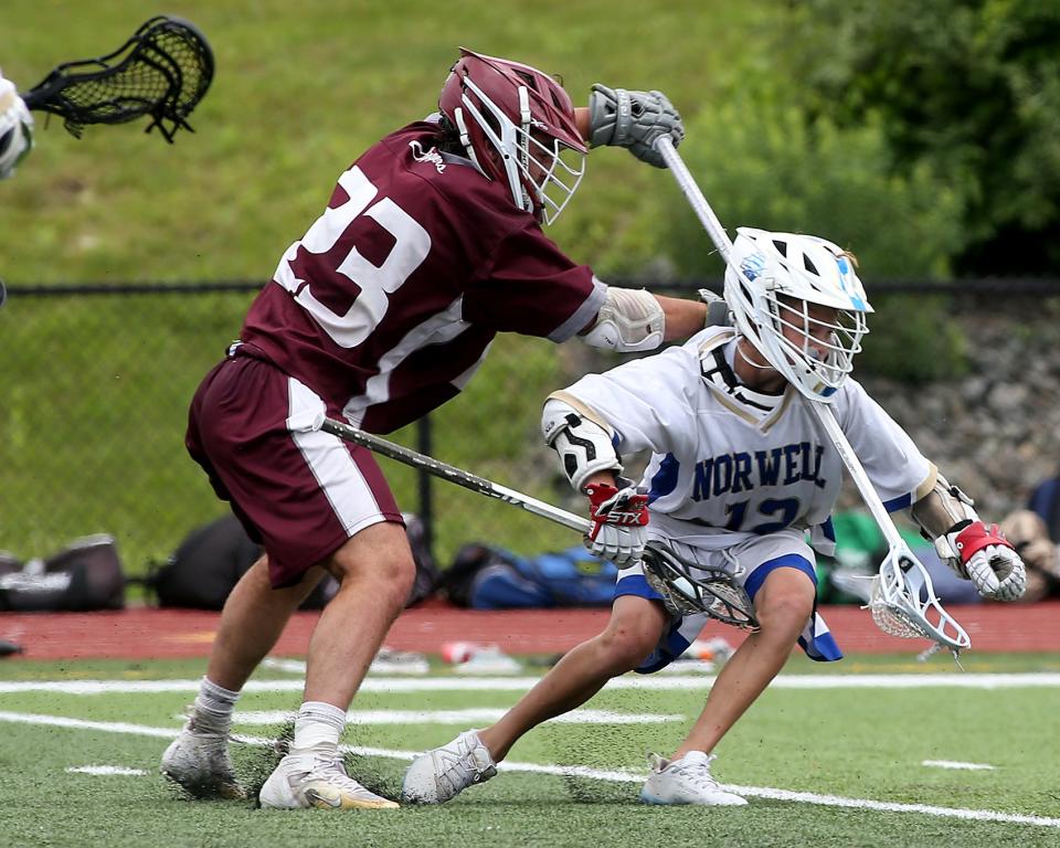 Norwell's Jake McGuirk earns a penalty after getting hit by Falmouth's Cooper Young during fourth quarter action of their game against Falmouth in the Division 3 state final at Burlington High on Saturday, June 18, 2023. Norwell won the state title 10-4.