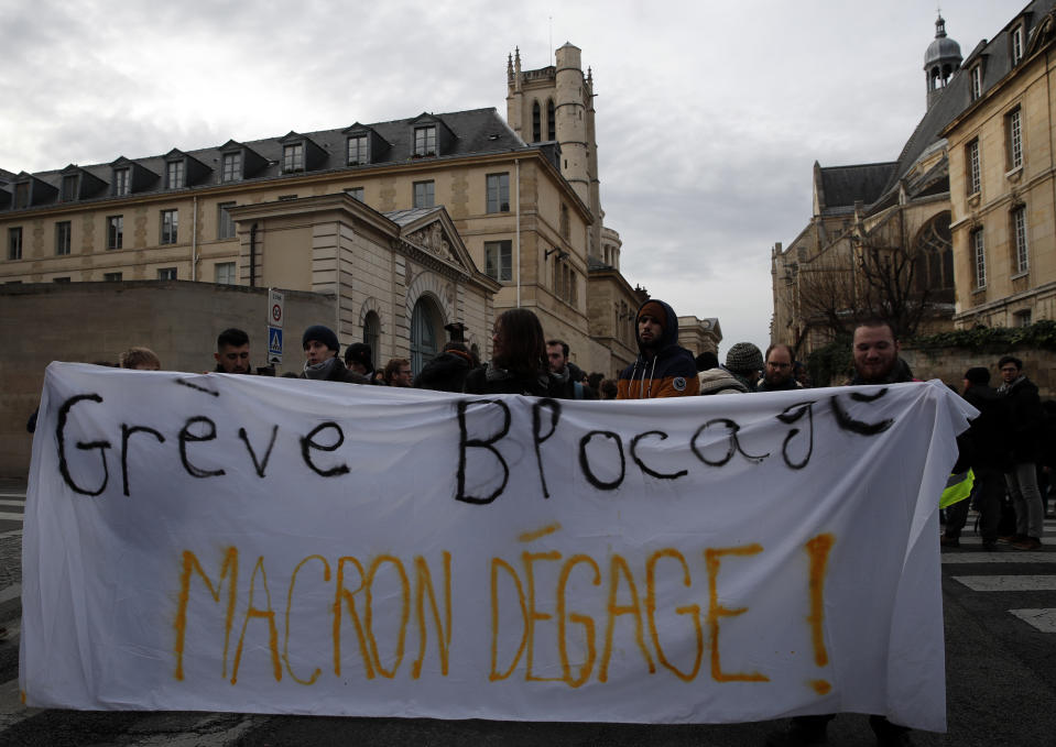 Students opposing changes in key high school tests, carrying a banner reading "Strike Blockade. Macron out " demonstrate Tuesday Dec.18, 2018 in Paris. Macron has acknowledged he's partially responsible for the anger that has fueled weeks of protests in France, an unusual admission for the leader elected last year. (AP Photo/Christophe Ena)