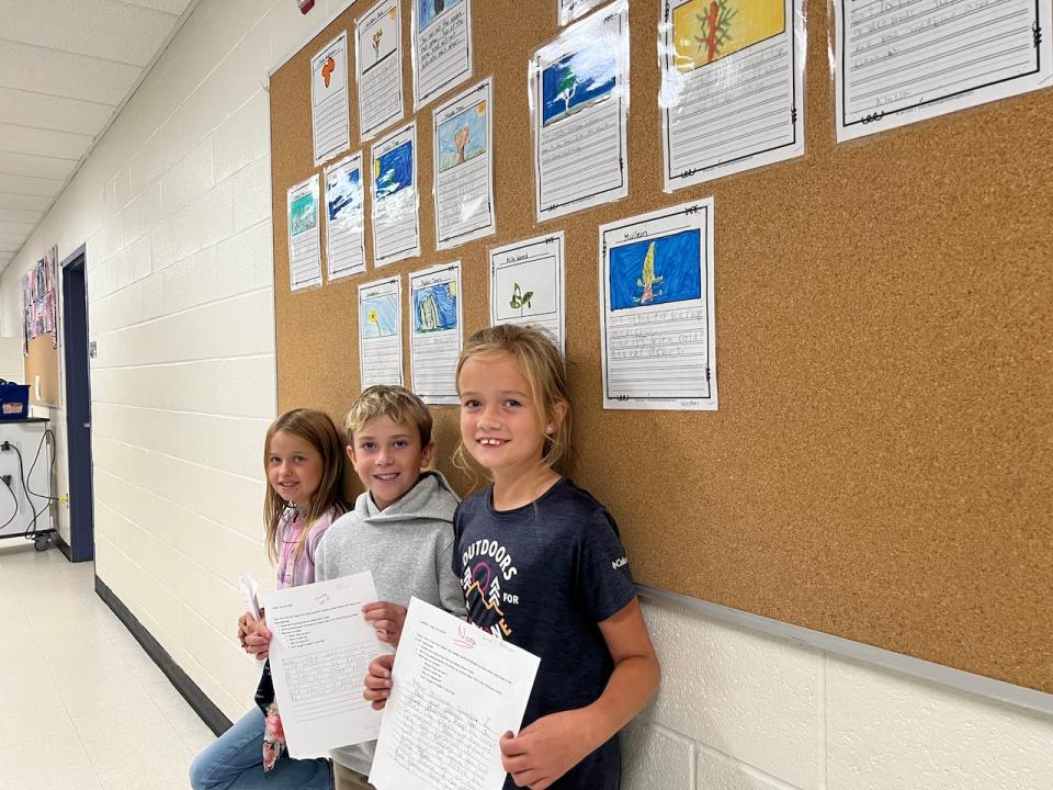 Millbrook, Ont. students Renee Olinger, from left, Oliver Howe and Nora Gemmiti share the school announcements they crafted after learning about the plants in the forest next to their school. They are seen on Wednesday, September 25, 2024.