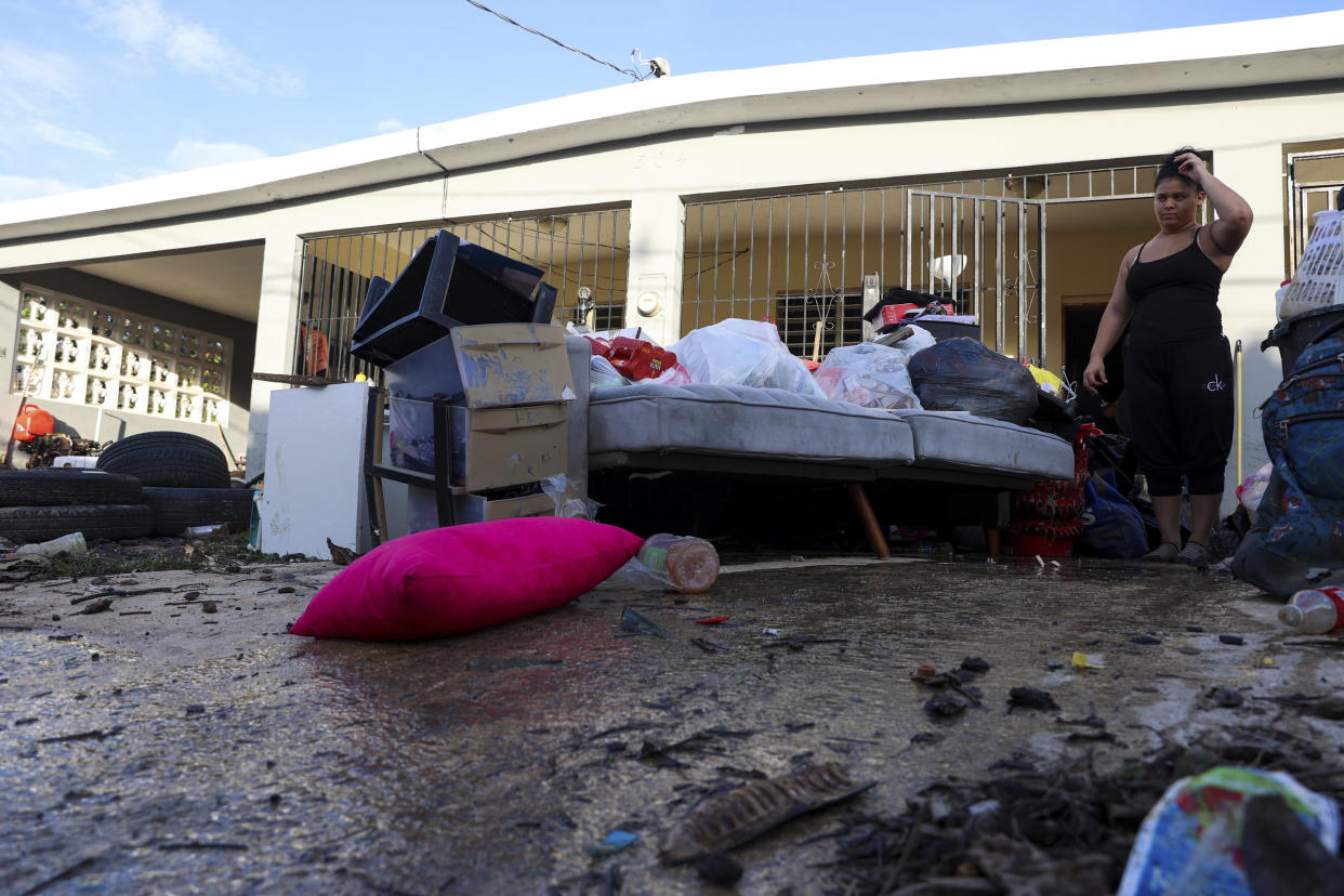 A woman looks at her water-damaged belongings after flooding caused by Hurricane Fiona tore through her home in Toa Baja, Puerto Rico. (Stephanie Rojas/AP)